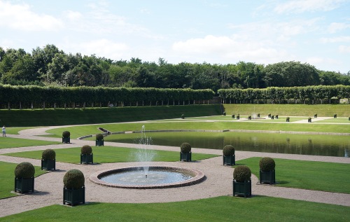 Circular fountains are aligned along either side of the reflecting pool.