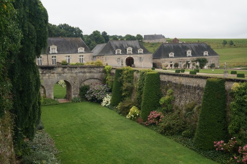 The moat separating the service court from the house area is now filled with garden plantings of shade-tolerant hydrangeas and yew buttresses.