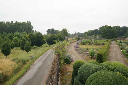 The gate at the end of the Potager leads to a walk across the more modern road into the naturalistic landscape, defined by walls from the designed garden spaces.